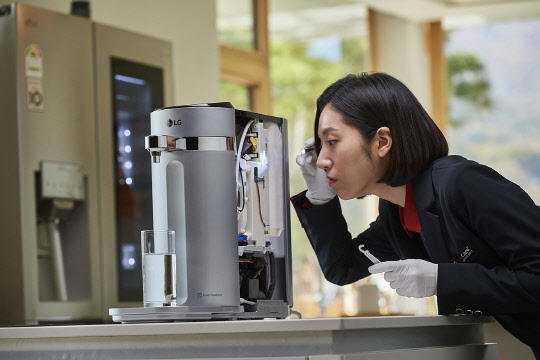 LG전자의 신개념 가전관리 서비스 '케어 솔루션'이 업계 최초로 고객만족경영시스템(ISO 10002) 인증을 받았다. LG전자 '케어솔루션 매니저'가 정수기를 꼼꼼하게 점검하고 있다. <LG전자 제공>